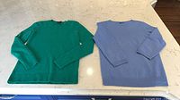 Green and blue cashmere sweaters laid flat