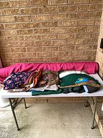 Table with rolled fuchsia fabric and stacked folded remnants
