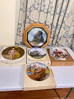 All five plates displayed with two in boxes and one framed