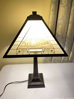 Full view of lamp showing pyramid glass shade, metal base, cord