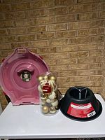 Open Sterilite wreath container, ornament package, tree stand on table