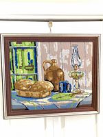 Full view of framed needlepoint still life hanging on wall