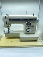 Front left view of Kenmore cream sewing machine on its base