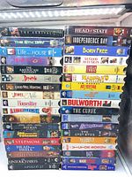 Two vertical stacks of assorted VHS tapes showing spines and titles