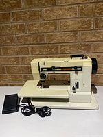 Front view of Pfaff Hobbymatic 807 sewing machine with foot pedal and power cord visible