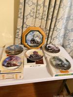 Group shot of all six train plates including framed piece and five boxed plates