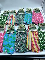 All ten pairs of gloves laid out showing assorted patterns and attached tags