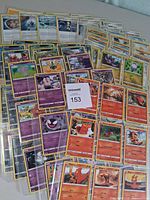Stack of Pokémon cards in plastic sheets showing various Fire and Psychic types