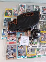 Full lot view with glove on trading cards and black baseball