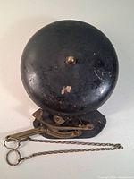 Front view of entire boxing bell showing bell, striker and chain