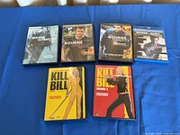 All six movie cases laid out: four Bourne titles and two Kill Bill volumes