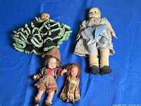 All four dolls laid out on blue surface for overview