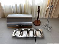 All four kitchen items: breadbox closed, banana holder, paper towel holder, divided tray