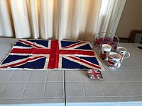 Full lot laid out: linen flag, glasses in caddy, mugs, coaster