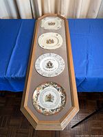 Full view of framed set showing four plates in blonde wood frame