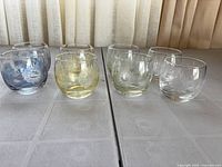 Eight etched color-tinted rocks glasses front view