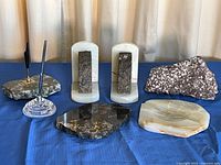 All seven stone desk items arranged on blue cloth