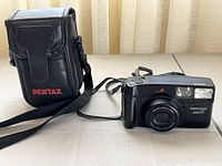Camera with case and strap on tiled surface