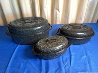 Three speckled enamel roasting pans with lids, nested together