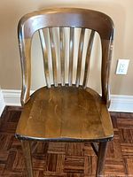 Front view showing curved top rail, six spindles, contoured seat and wear