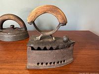 Front view showing iron, wood handle, vent holes, latch