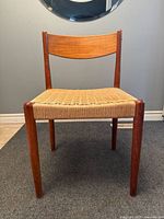 Front view of teak side chair showing woven cord seat and curved backrest