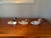 All three carved wooden ducks on table