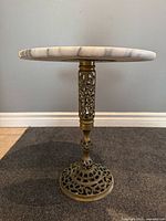 Side view of full table showing marble top and brass pedestal