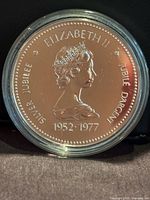 Obverse of 1977 Silver Jubilee specimen dollar in capsule
