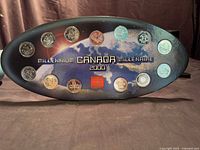 Front view of oval display holder showing 12 coins around Earth graphic