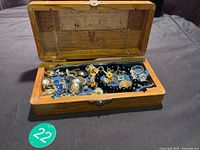 open wooden box with assorted jewellery items