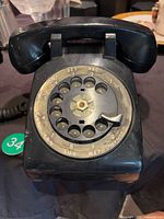 Front view of black Northern Electric rotary dial telephone showing dial and base