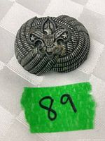 Front view of metal slide showing BSA emblem and rope design