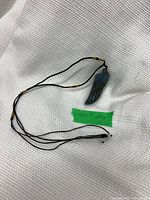 Full view of necklace showing cord, beads and angel wing pendant