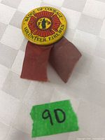 front view of Badge of Courage volunteer firemen pin showing text, emblem, and ribbons