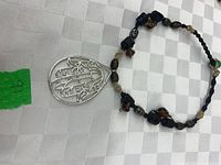 Entire necklace showing bead pattern and large silver-tone pendant