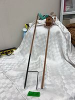 Complete garden stake parts laid out: birdhouse top section, two poles, black ground stake