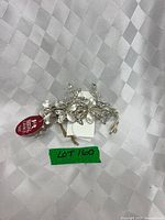 Hair clip front view showing floral design and tag