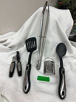 all five utensils laid out on white cloth