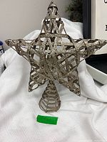 Front view of 3D wicker star tree topper showing cone base and lattice design