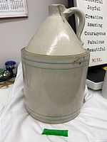 Full view front showing stoneware jug crock with handle and blue bands