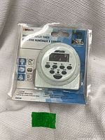 Front of sealed Woods digital outlet timer showing LCD face and control buttons