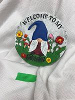 Front view of round garden stone showing gnome design and inscription