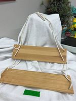 Full view of two wooden boards connected by white rope for hanging shelf