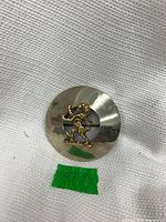 Front view showing silver disc and gold lion emblem