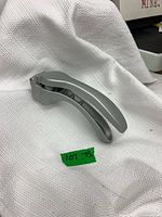 Side view of gray Pampered Chef garlic press on white cloth