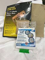 Front view of Duramax sandpaper pack and Polar Bear outlet seals package with loose sandpaper sheet
