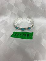 Full view of silver-tone cuff bracelet showing three blue cabochon stones