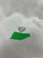 Ring on white fabric showing full form and green lot marker