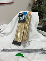 sealed pack and bagged bamboo skewers with metal skewers in foreground